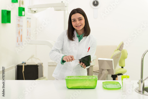 Young Female Dentist Working On The Mould