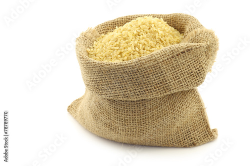 ulgur (couscous) in a burlap bag with an aluminum scoop on a wh