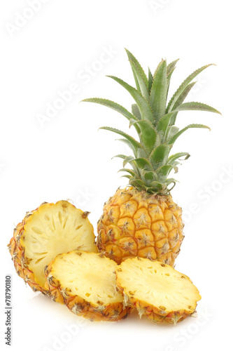 fresh mini pineapple fruit and a cut one on a white background