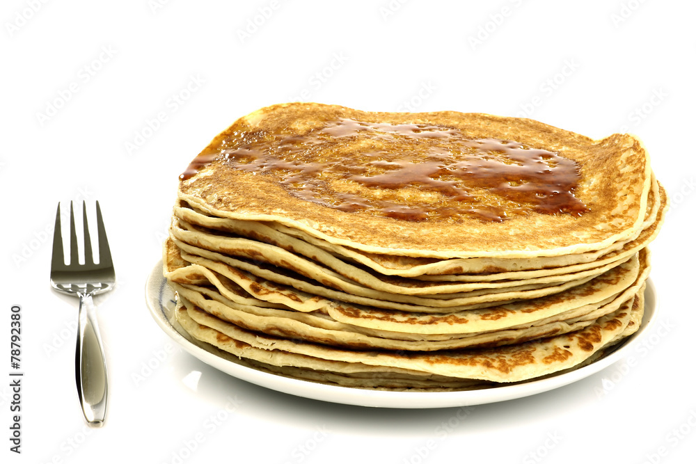 a plate with stacked freshly baked pancakes with a fork