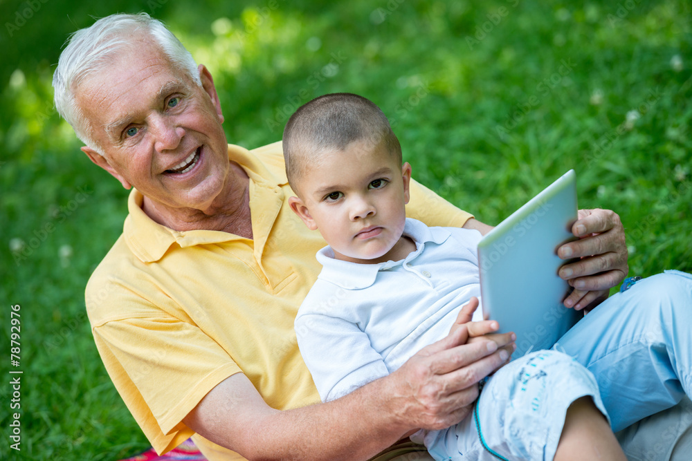 grandfather and child in park using tablet grandfather and child in park using tablet