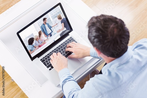 Composite image of high angle view of casual man using laptop