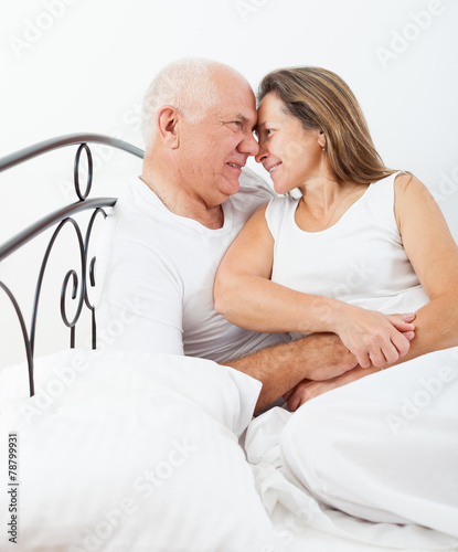 elderly couple embracing in bed. © DariaTrofimova