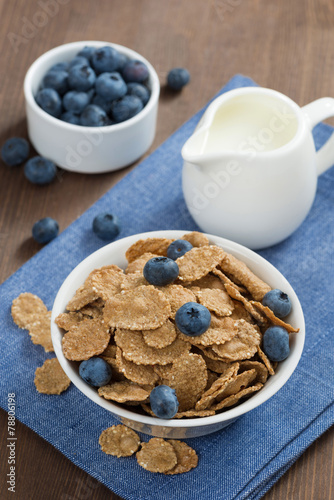 wholegrain flakes with blueberries and milk, vertical, top view