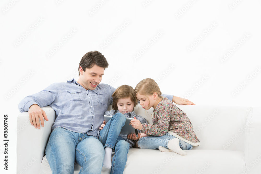 father with children playing touchpad at home. father with children playing touchpad at home.