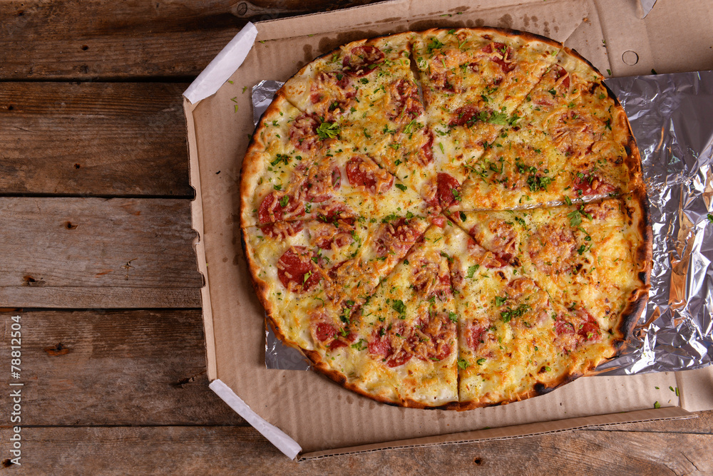 Tasty pizza in box on wooden background Tasty pizza in box on wooden background