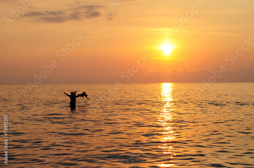 Happy father and son swimming in the sea at beautiful sunset © bildlove