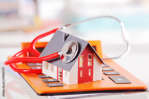 Model House with Stethoscope on Calculator Device photo