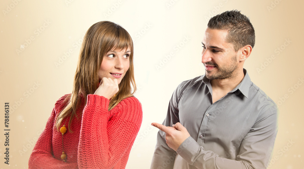 Man pointing his girlfriend over white background Man pointing his girlfriend over white background