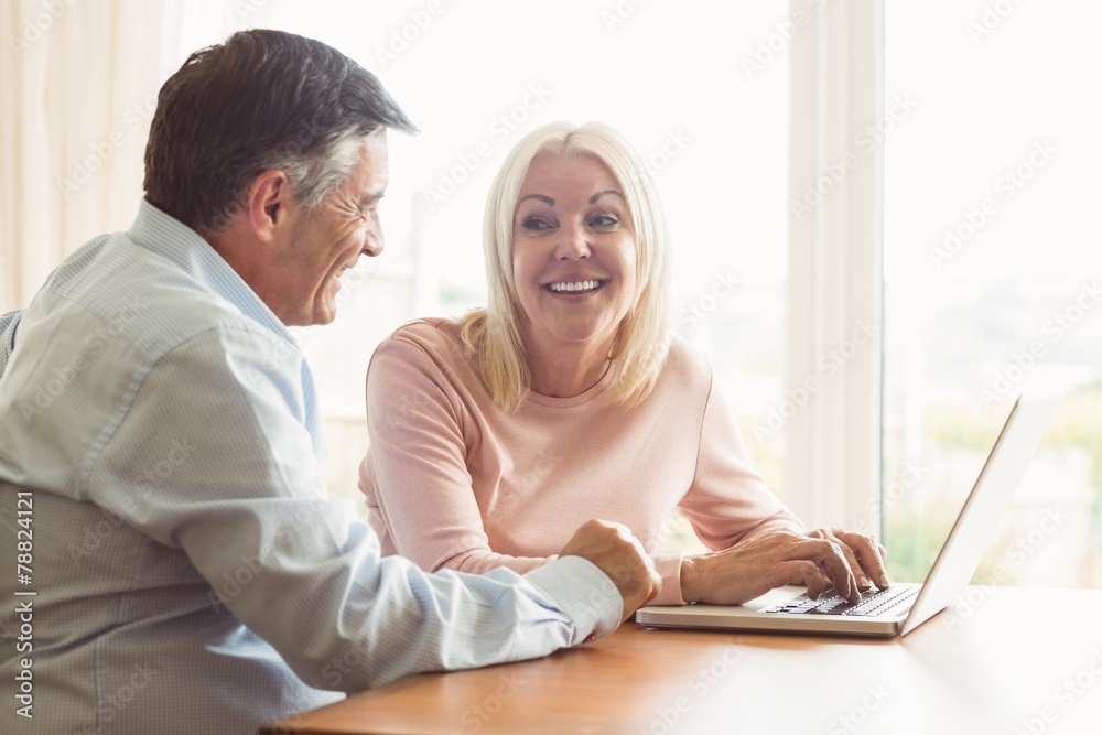 Happy mature couple using laptop