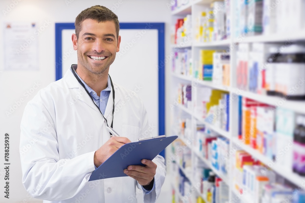 Handsome pharmacist writing on clipboard Handsome pharmacist writing on clipboard
