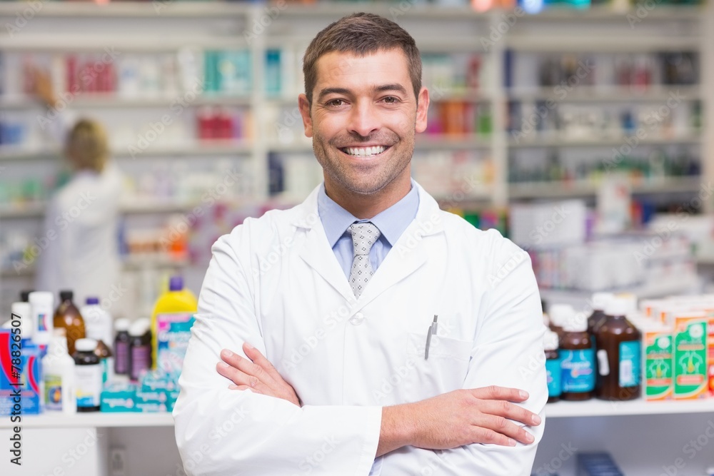 Smiling pharmacist in lab coat looking at camera