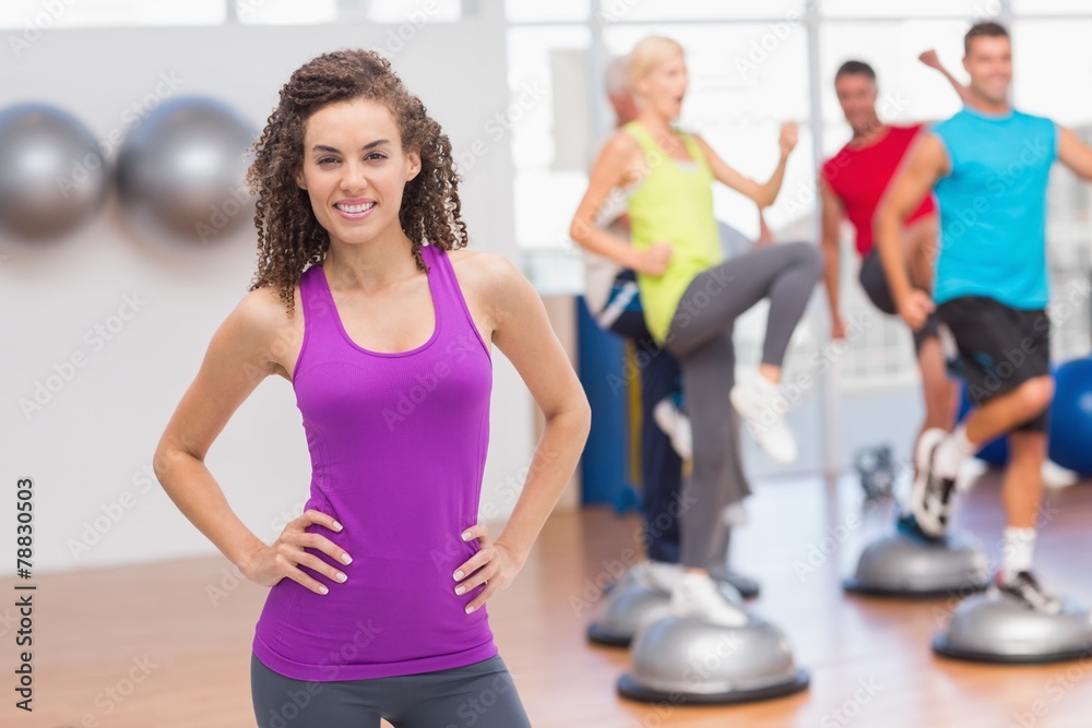 Happy fit woman standing hands on hips at gym Happy fit woman standing hands on hips at gym