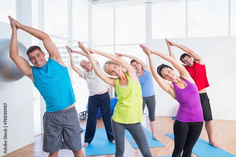 Happy people doing stretching exercise in yoga class Happy people doing stretching exercise in yoga class