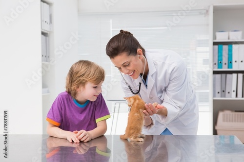 Veterinarian examining a cat with its owner