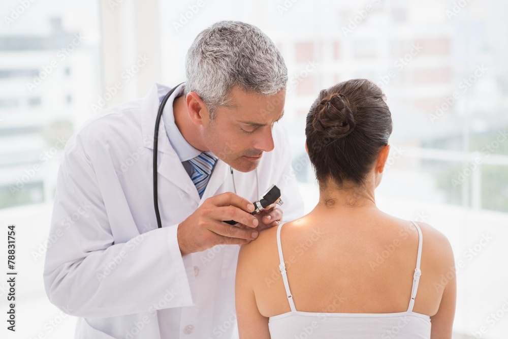 Fototapeta premium Doctor examining a spot at his patient
