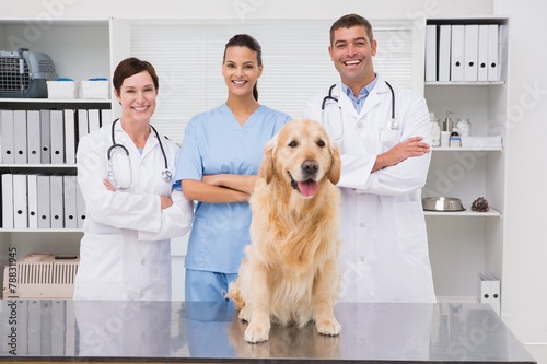 Veterinarian coworker smiling at camera with dog