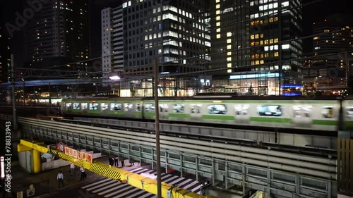 Train Passes over Bridge in Central Tokyo Japan at Night photo