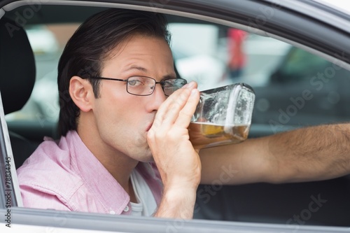 Man drinking alcohol while driving