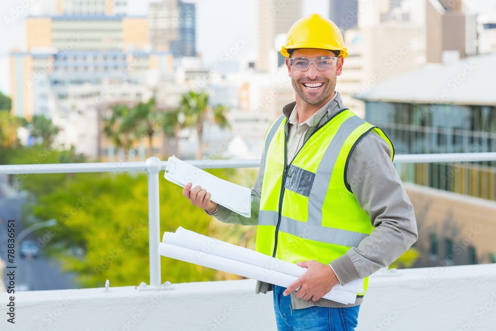 Smiling male architect with blueprints and clipboard Smiling male architect with blueprints and clipboard