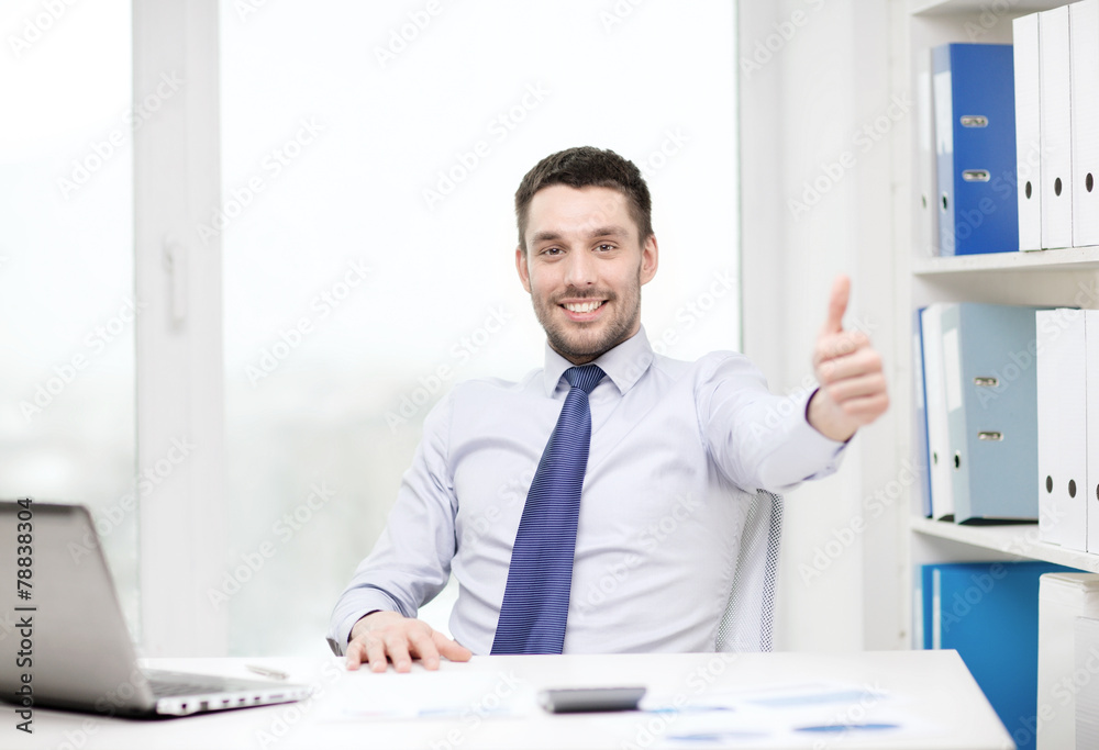 smiling businessman with laptop and documents