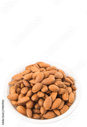 Raw almond nut in a white bowl over white background