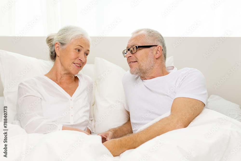 happy senior coupler lying in bad at home happy senior coupler lying in bad at home