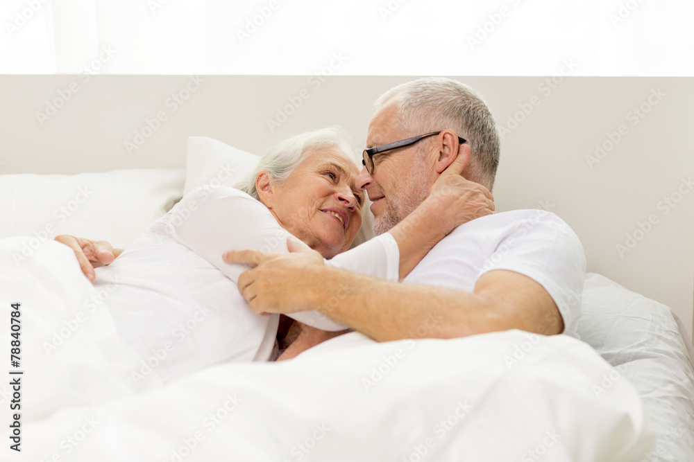 happy senior coupler lying in bad at home happy senior coupler lying in bad at home