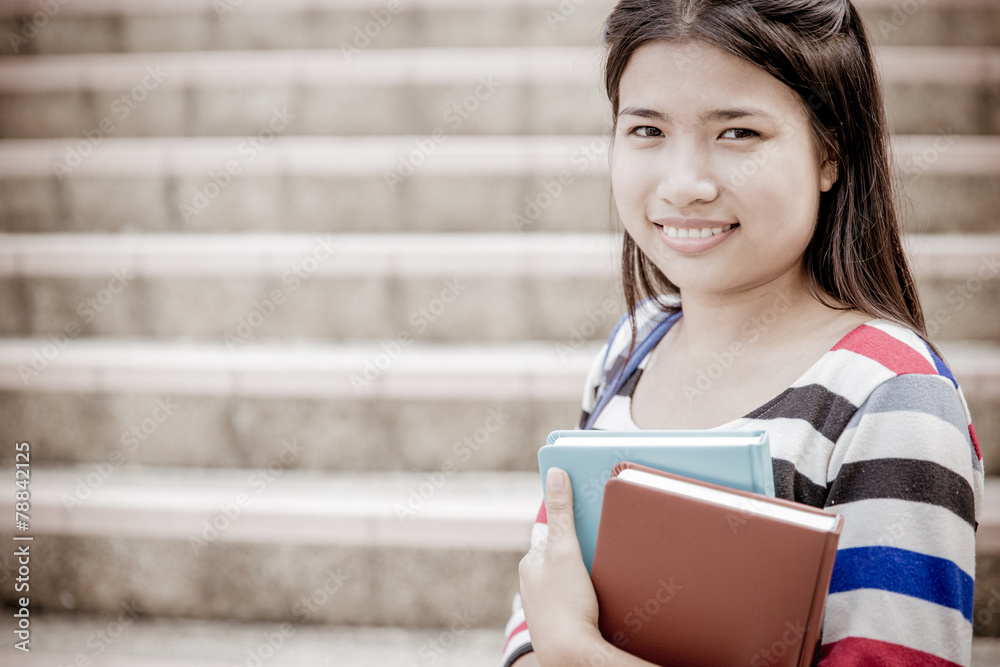 Obraz premium attractive female college student sitting on stairs