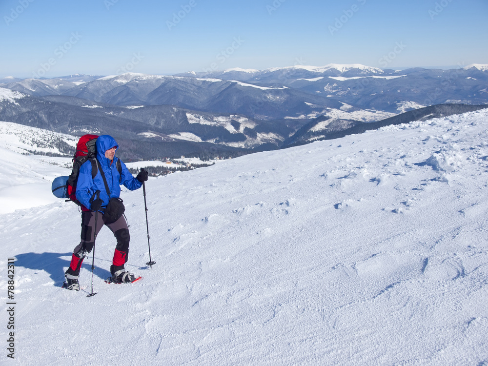 The man in snowshoes in the mountains.