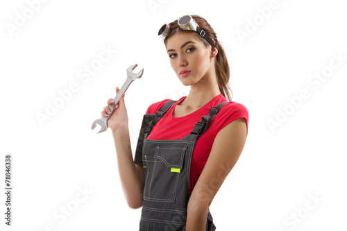 The girl stands with a wrench