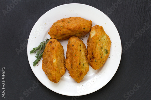 fish croquettes on plate on black background photo