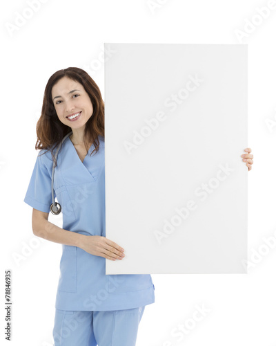 Smiling friendly female doctor or nurse showing a blank white bi
