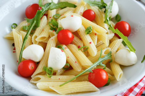 Penne with tomatoes and slices of mozzarella cheese