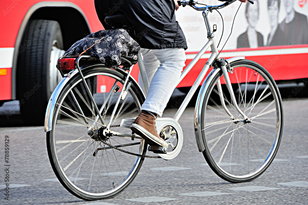 Obraz premium Bicyclist in traffic, bus in background