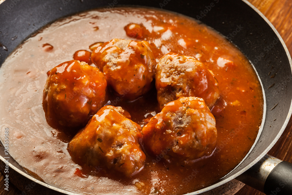 Meatballs with tomato sauce on black pan Meatballs with tomato sauce on black pan