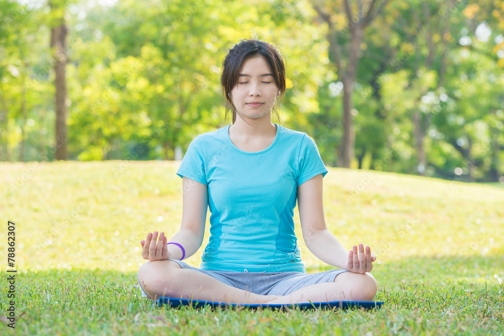Asian woman practicing yoga,Breath Retention pose, in park Asian woman practicing yoga,Breath Retention pose, in park