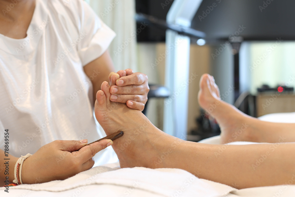 © bignai - Woman receiving a Reflexology foot massage
