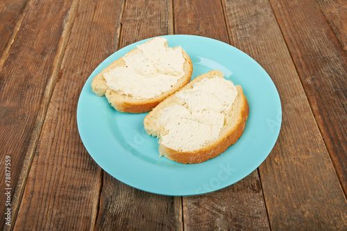 Sandwiches with cream cheese on a wooden table