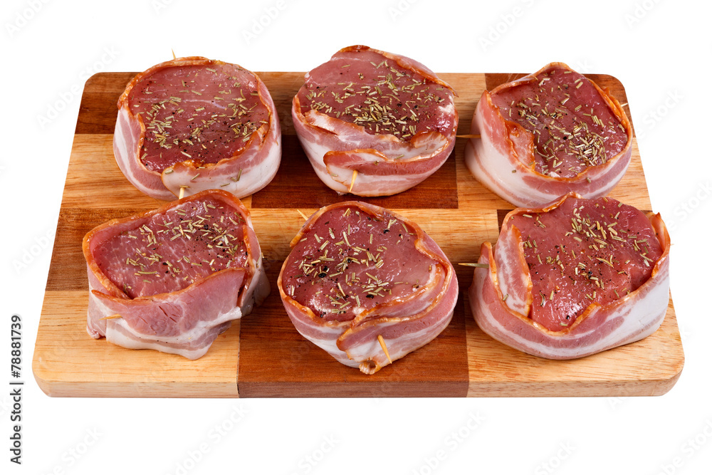 Steak with bacon and spices prepared for grilling. Isolated