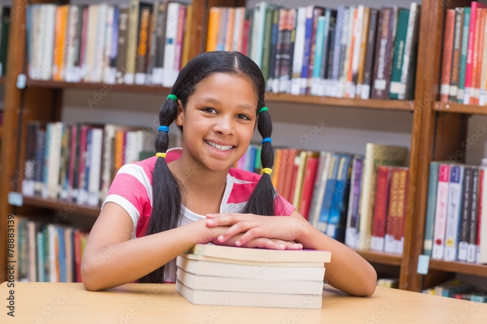 Cute pupil looking at camera in library Cute pupil looking at camera in library