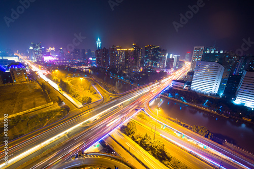 traffic light trails on overpass and cityscape at night © zhu difeng