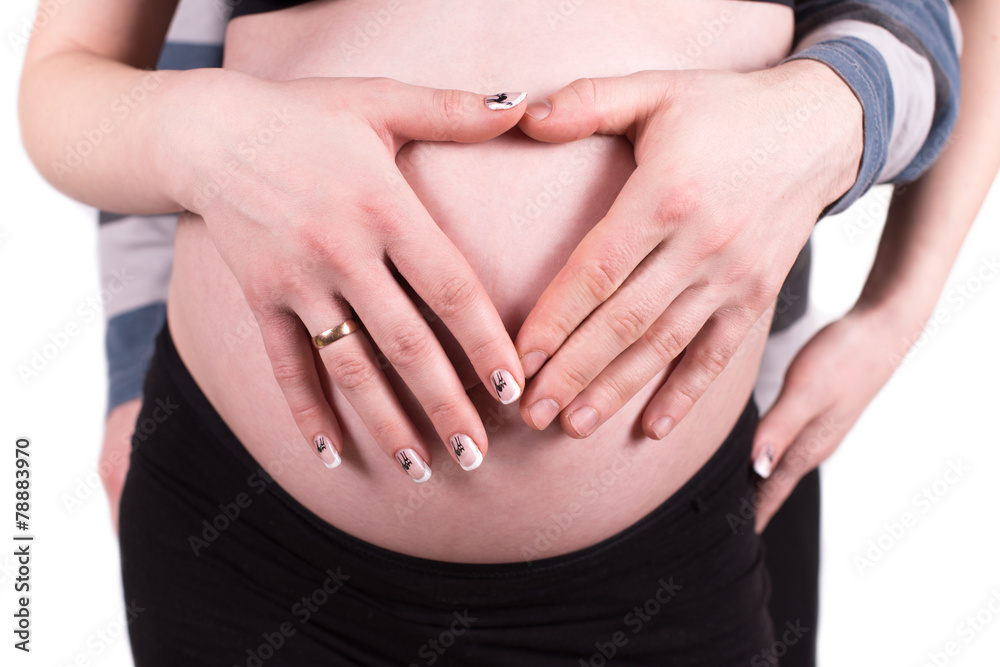 Heart shaped hands of pregnant woman and her husband