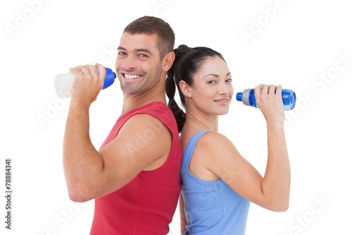 Fit man and woman smiling at camera together