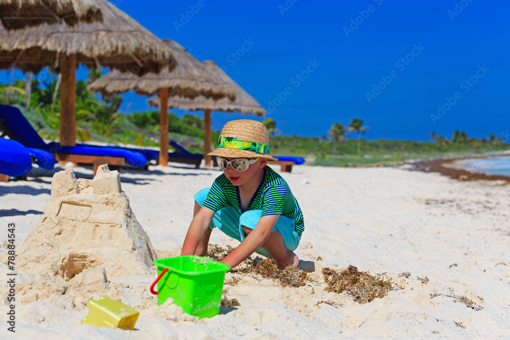 little boy building sandcastle on tropical beach little boy building sandcastle on tropical beach