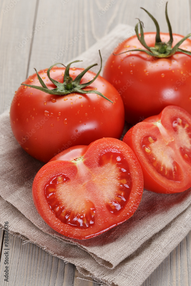 fresh ripe tomatoes with halfs on wood table fresh ripe tomatoes with halfs on wood table