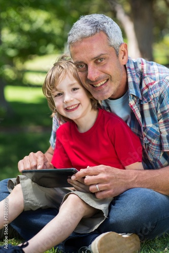 Happy father using tablet pc with his son