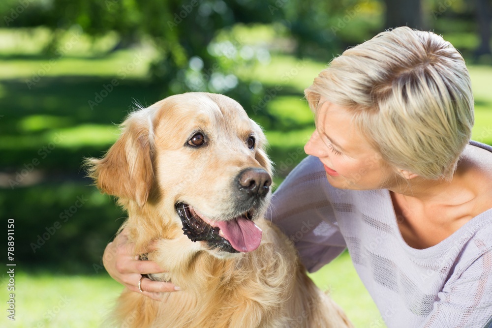 Happy blonde with her dog in the park Happy blonde with her dog in the park
