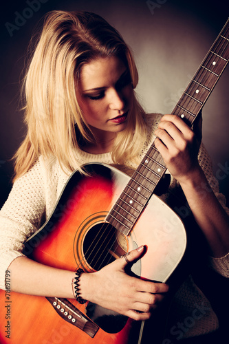 Portrait of young blonde guitar player woman
