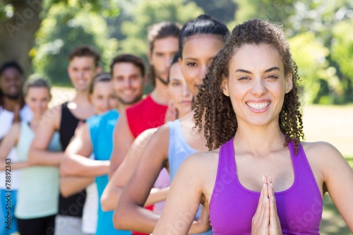 Fitness group doing yoga in park